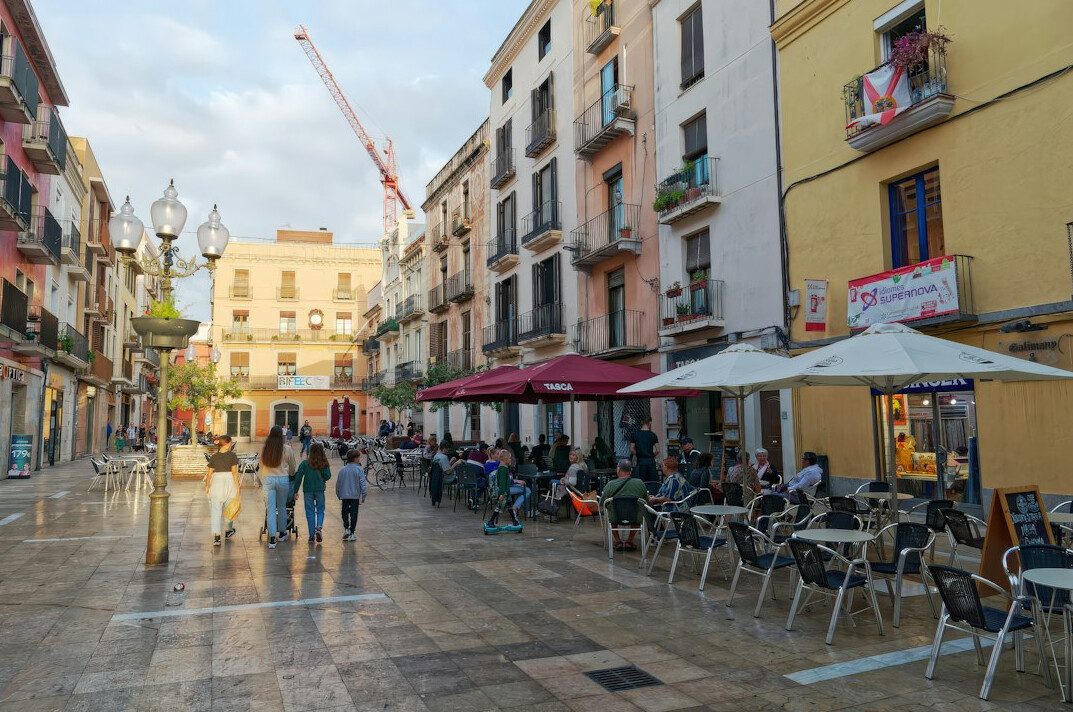 Quiet city square with shops and cafe terraces in the morning